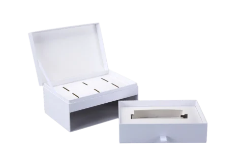 Two custom rigid boxes, one displayed open with compartmental slots inside, and the other partially opened to reveal a flat insert tray.
