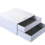 A white, sturdy two-drawer packaging rigid box with one drawer partially open and the other fully extended, showcasing a sleek and minimalist design.