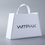 Trapezoidal book-style rigid box with straps