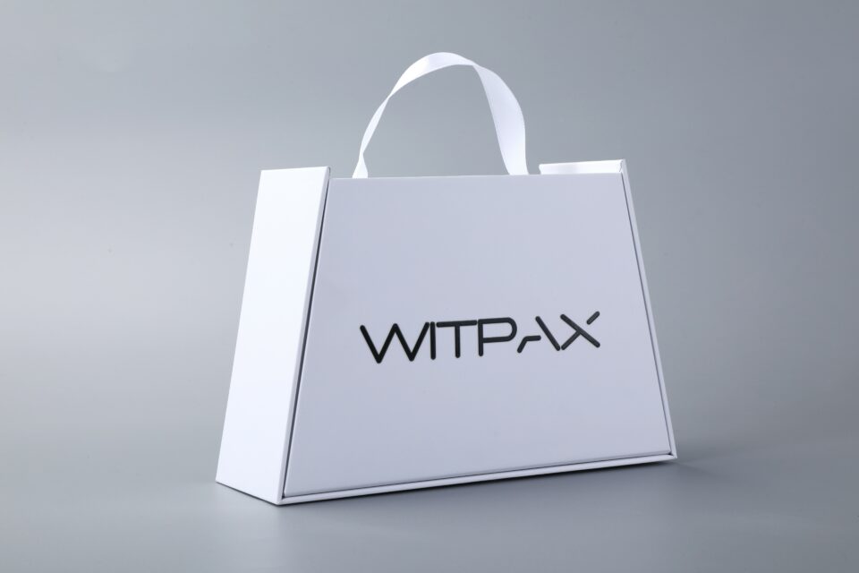 Trapezoidal book-style rigid box with straps