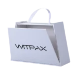 A pristine white shopping bag with a ribbon handle and a front flap that partially opens, designed to resemble the sleek, sturdy construction of a high-quality rigid box.