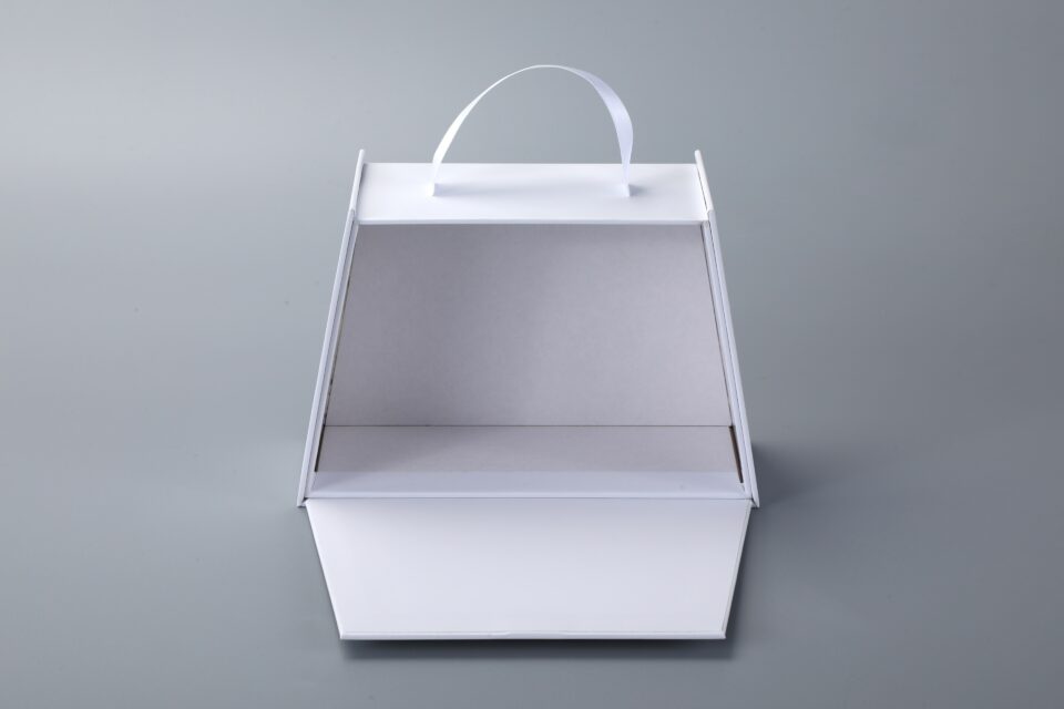 Trapezoidal book-style rigid box with straps