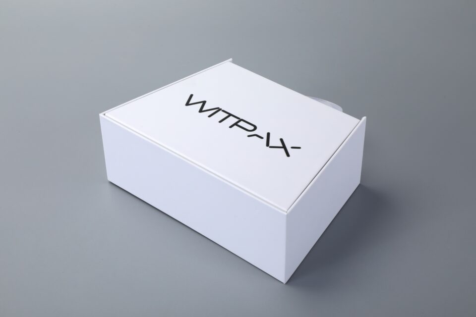 Trapezoidal book-style rigid box with straps