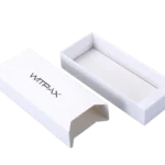 The image depicts a white rectangular rigid box with its lid removed, showcasing the internal compartment.