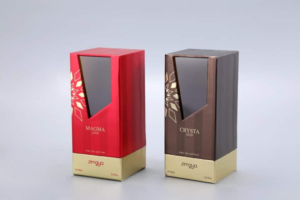 We are a manufacturer of custom box packaging. This image showcases our product line: two distinct perfume boxes set against a neutral gray background. The box on the left features a bold red design, while the box on the right presents an elegant brown hue. Both boxes carry our brand "zimaya" and are labeled as "eau de parfum.