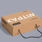 The image showcases a custom-designed brown cardboard box equipped with durable handles, optimized for easy carrying. It's specifically crafted to ensure the safety of fragile items during transport. The box is set against a neutral gray background, emphasizing its practical and protective features as a mailer solution.