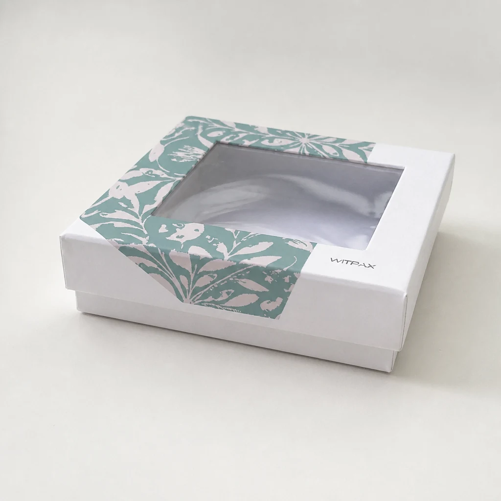 Closed rigid box with clear window and teal floral printed frame