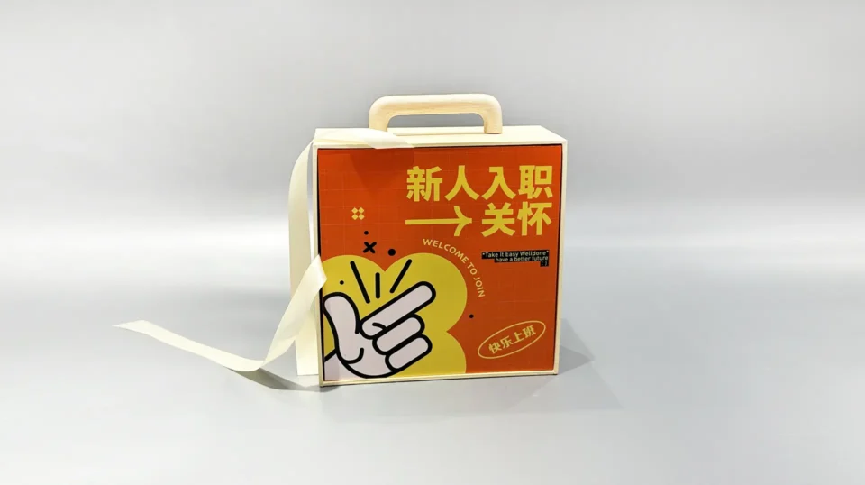 Beige custom packaging box with a detachable orange lid, featuring an artistic design and adjacent loose ribbon