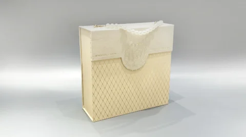 Our product is a luxury gift box in an elegant beige tone, featuring a sophisticated diamond pattern. It is accented by a pearl-like handle and embellished with an embossed floral design. The box includes a magnetic closure on the flap, combining both elegance and functionality for a premium packaging solution.