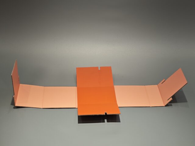 Orange Mecca box featuring a stylized face illustration