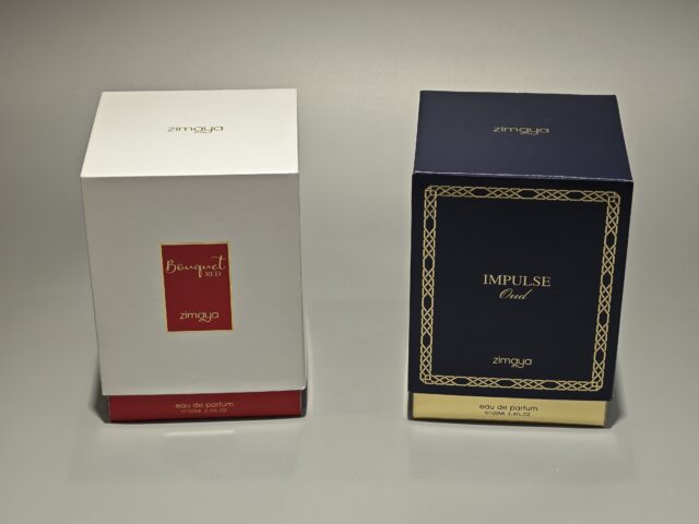 Displayed side by side are two elegant perfume packaging boxes. The box on the left showcases a pristine white finish, while the box on the right features an alluring dark shade. Both boxes are adorned with intricate gold stamping, adding a touch of handmade artistry and luxury to their design.