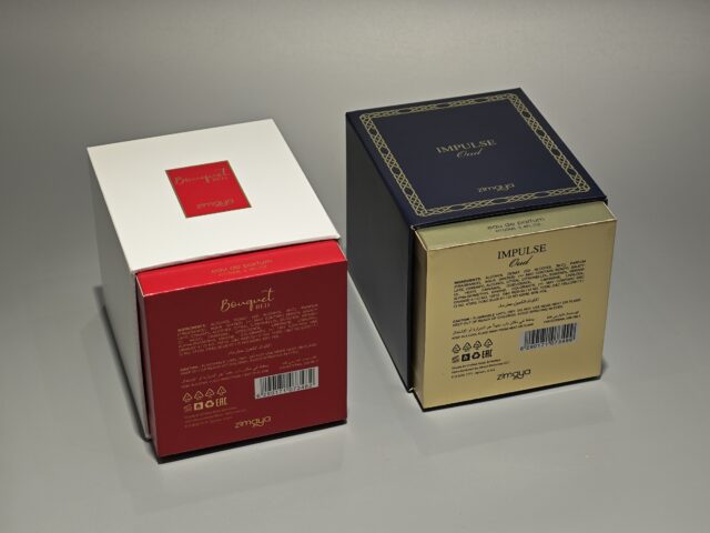 Displayed side by side are two elegant perfume packaging boxes. The box on the left showcases a pristine white finish, while the box on the right features an alluring dark shade. Both boxes are adorned with intricate gold stamping, adding a touch of handmade artistry and luxury to their design.