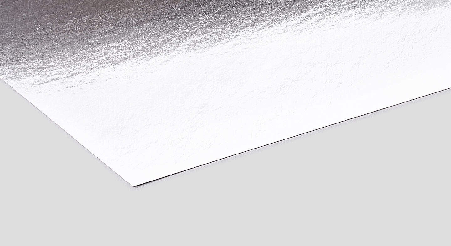 The image portrays a corner section of a sleek, metallic silver packaging material set against a simple gray backdrop.