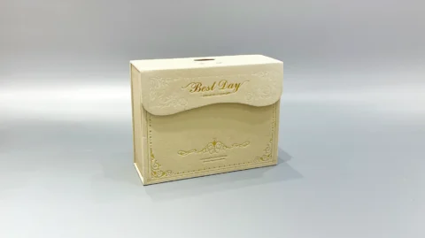 A custom flip-top gift box in beige, featuring unique textures, is displayed against a plain gray backdrop.