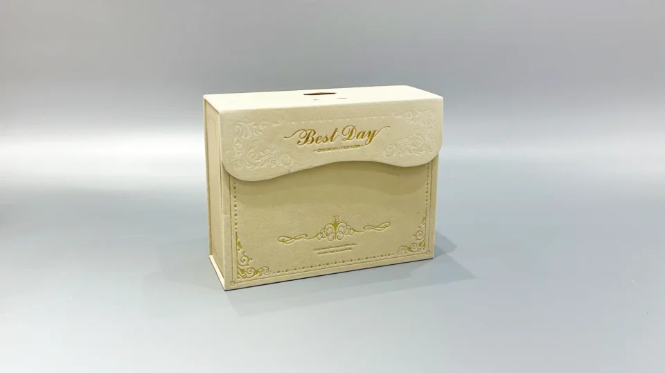 A custom flip-top gift box in beige, featuring unique textures, is displayed against a plain gray backdrop.