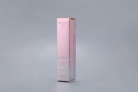 A custom pink and white box designed for "Heuyea Soothing Essence" set against a gray background.