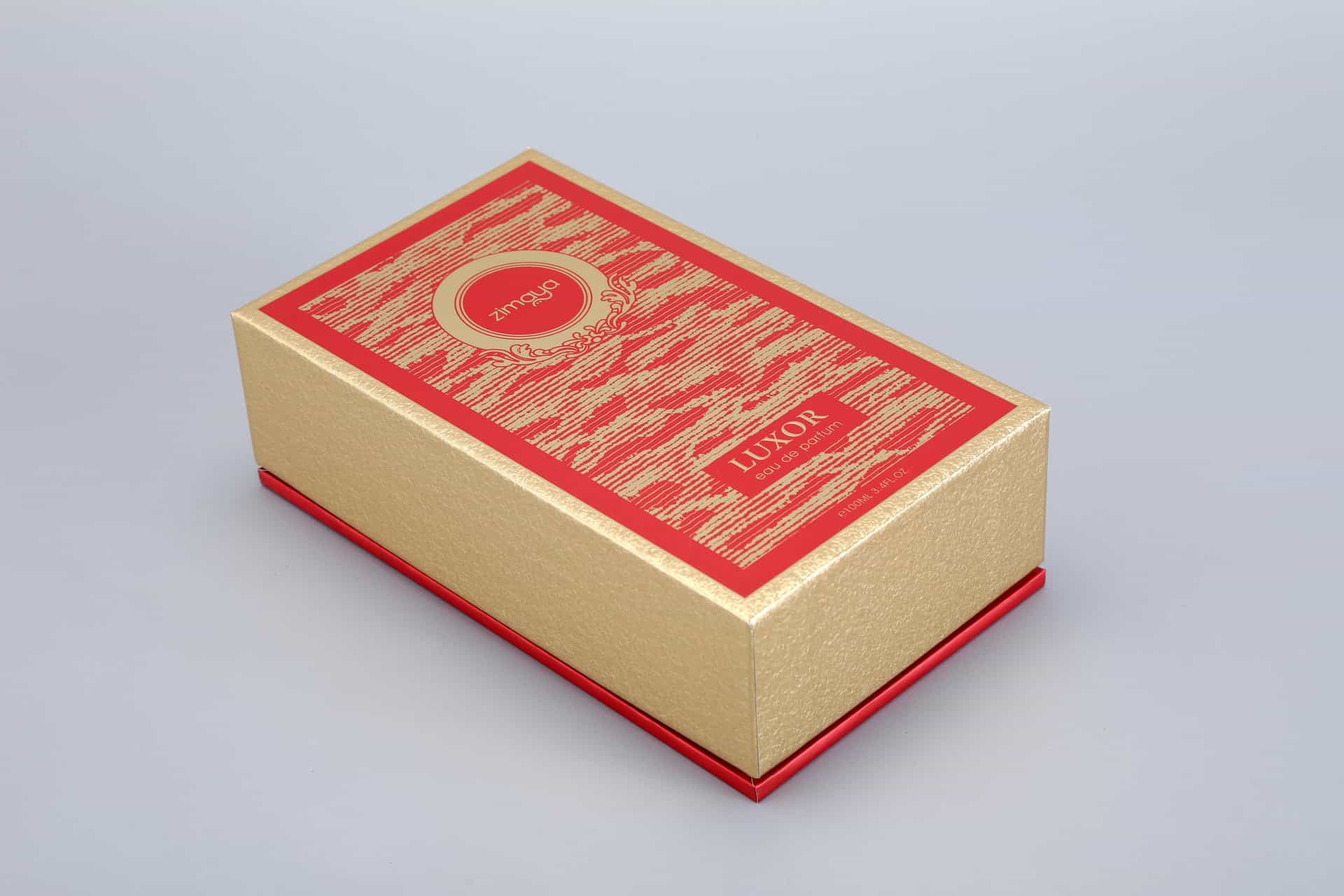 A luxurious gold and red rectangular box adorned with intricate designs is set against a plain background.