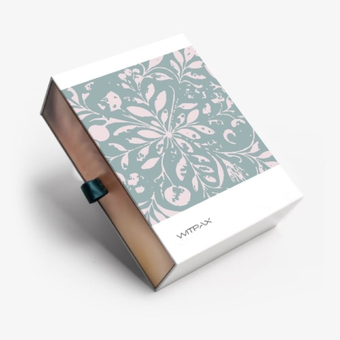 Custom collapsible rigid box with sage green floral pattern lid and bronze base, shown partially open with ribbon pull tab