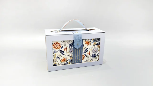 Custom-designed portable box packaging with a lid and handle, showcasing an elegant floral and bird pattern in blue, orange, and white tones. Ideal for gifting or personal use.