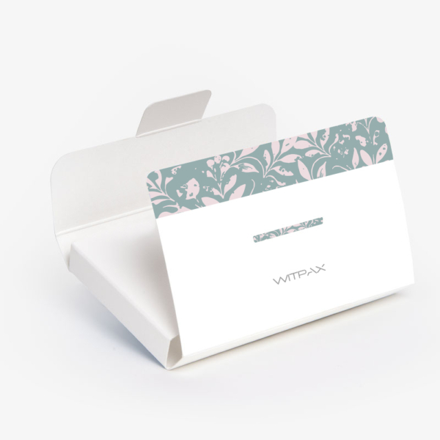 Custom folding carton with floral print window panel shown assembled with tuck-top closure open