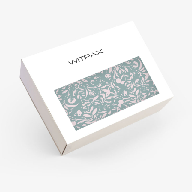 Closed custom folding carton showing white exterior with WITPAX branding and decorative sage green botanical window panel