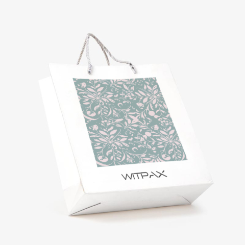 Custom white paper shopping bag with floral pattern panel and rope handles shown at an angle