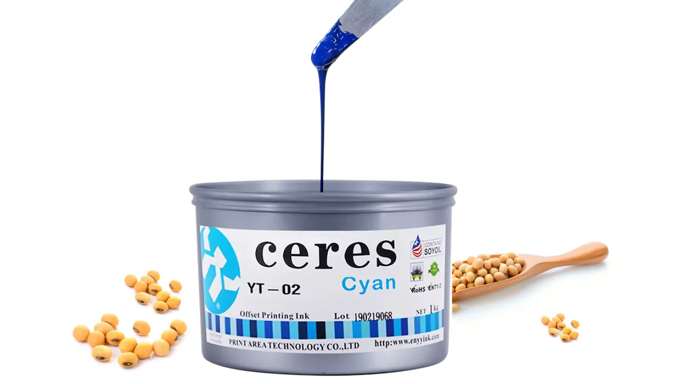 Cyan printing ink being poured from a spatula into a tin, with soybeans nearby.