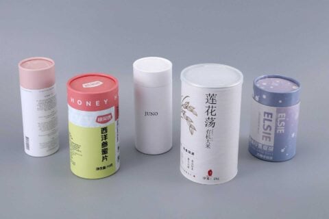 Five custom cylindrical boxes with unique designs, showcased against a plain background.