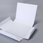 Foldable magnetic box, unfolded on gray surface, ready for assembly.