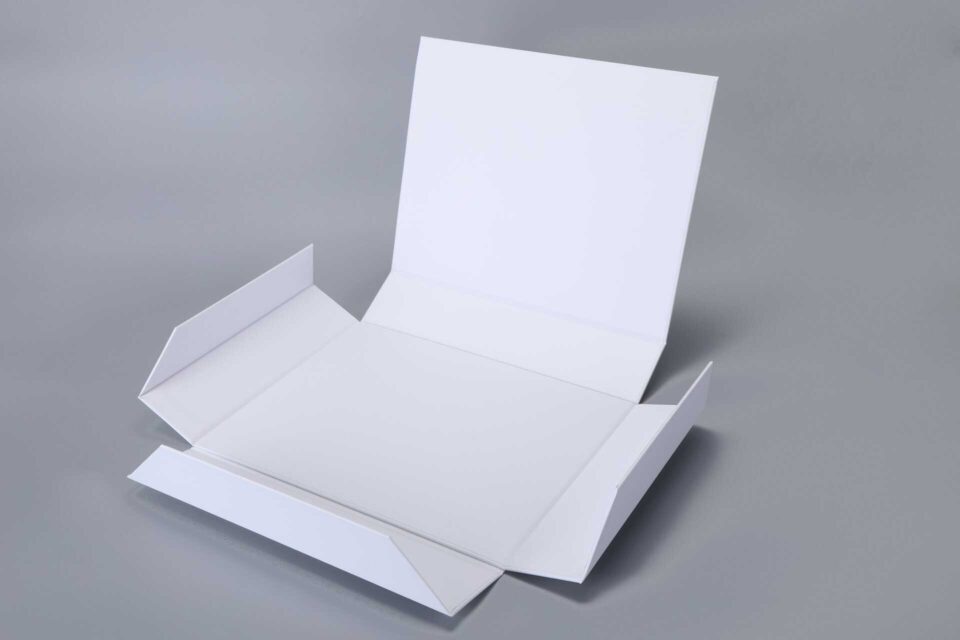 Foldable magnetic box, unfolded on gray surface, ready for assembly.