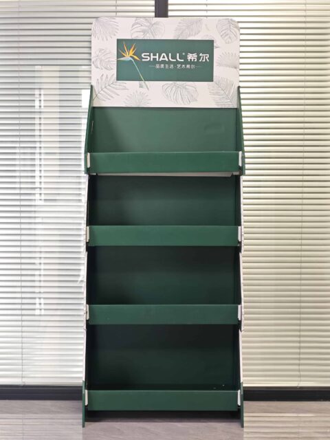The custom tray display with a branded top sign stands empty and vibrant, its four-tier design elegantly spotlighted against a backdrop of closed blinds.