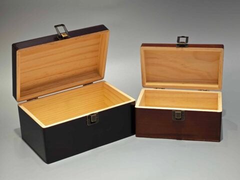 The image features two custom packaging boxes with hinged lids and metal clasps, presented on a plain background. One box is larger in size, while the other is smaller, illustrating the versatility in packaging solutions.