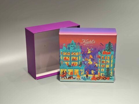 The image showcases a vibrant, customized gift box adorned with lively illustrations of people and animals. It features a unique skincare packaging design, paired with a distinct purple lift-off lid placed nearby.