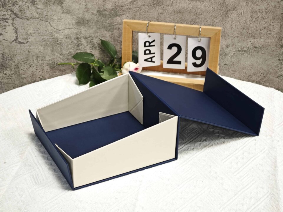 The image showcases an open navy and white collapsible rigid box