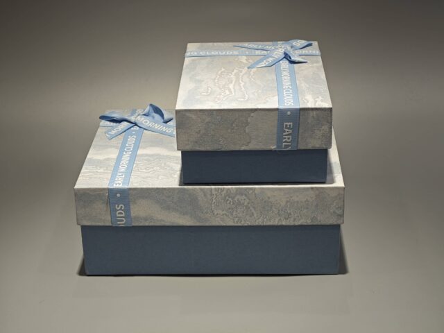 The boxes feature a blue and marbled pattern with a practical lift-off lid and are elegantly finished with blue ribbons.