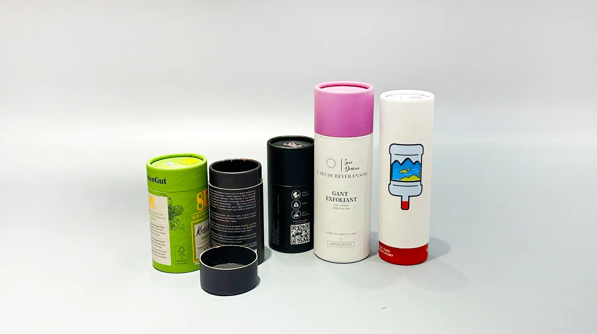 The image showcases various cylindrical packaging boxes designed for products such as deodorant and skincare items. These boxes are displayed upright against a plain background, resembling elegant round gift boxes.