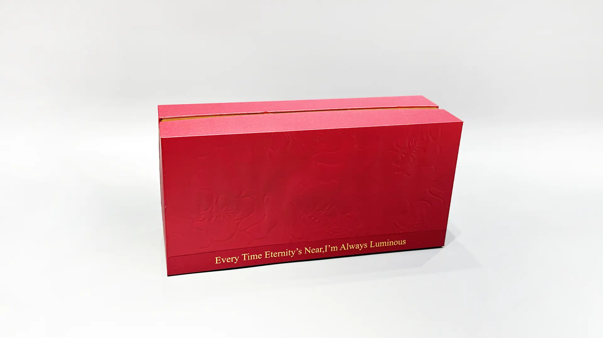 a red rectangular gift box featuring embossed floral patterns and elegant gold detailing.