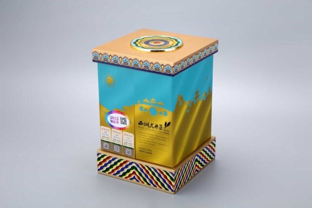 This image depicts a vibrant packaging box featuring intricate patterns and a car design, complemented by a circular emblem on the lid.