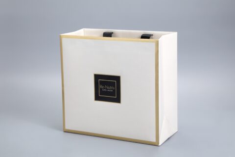 This image depicts a white Estee Lauder Re-Nutriv packaging box featuring elegant gold accents and a sleek design, highlighted against a neutral gray background.