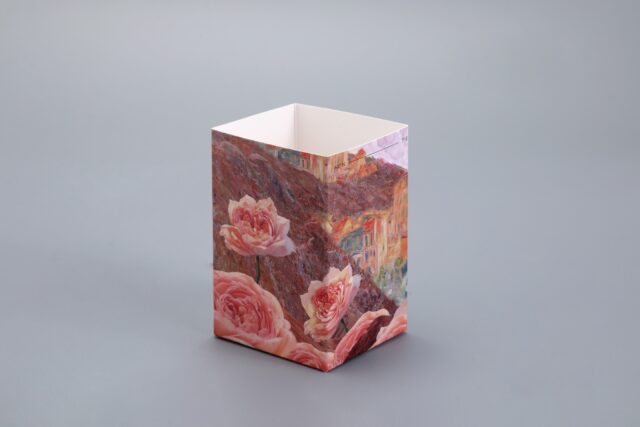 This image showcases a custom rectangular packaging box featuring an elegant floral and landscape design set against a sophisticated gray backdrop.