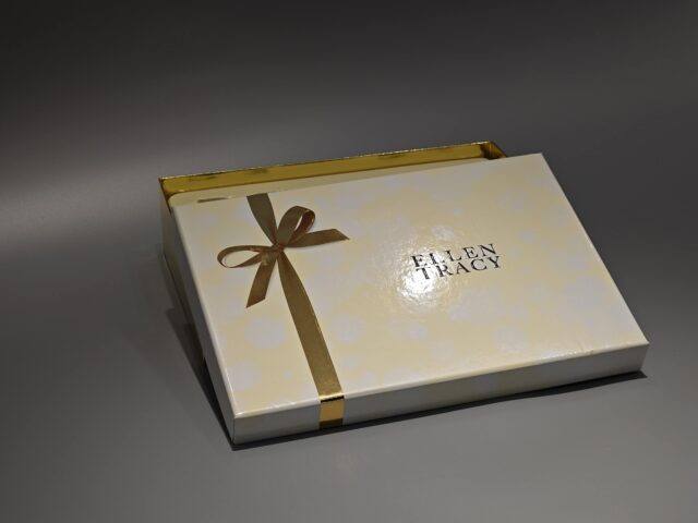 A closed lift-off lid box adorned with a luxurious gold ribbon. The design highlights elegance and sophistication, making it ideal for premium products.