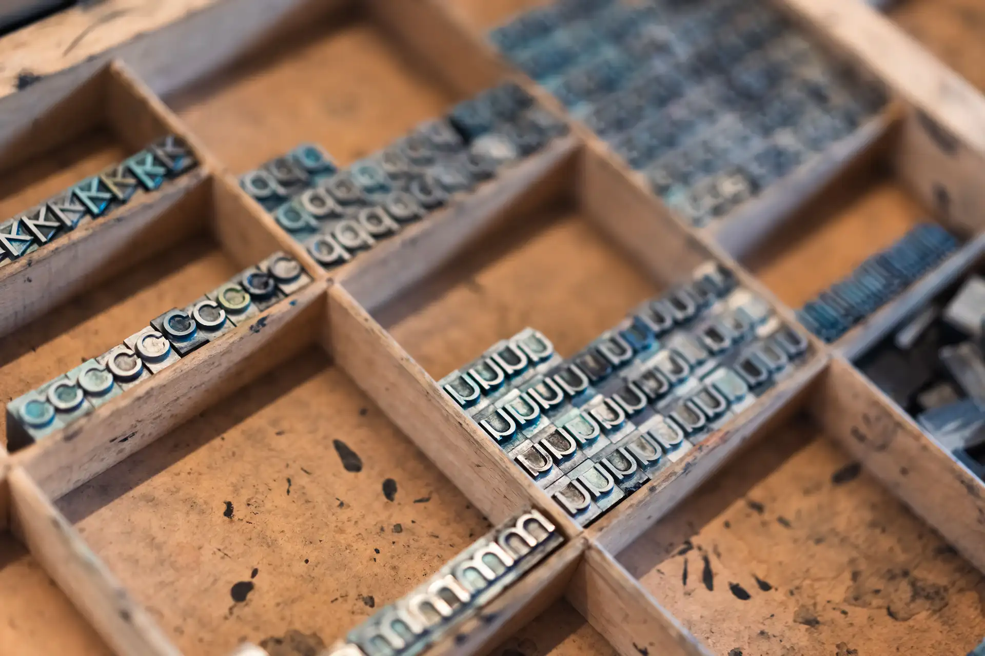 Tray with vintage metal letterpress type organized in sections.