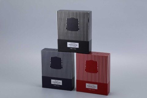 We are a manufacturer of custom box packaging. This image represents our product. It features three vertically striped boxes in different colors—black, blue, and red—arranged in a pyramid formation on a gray background.