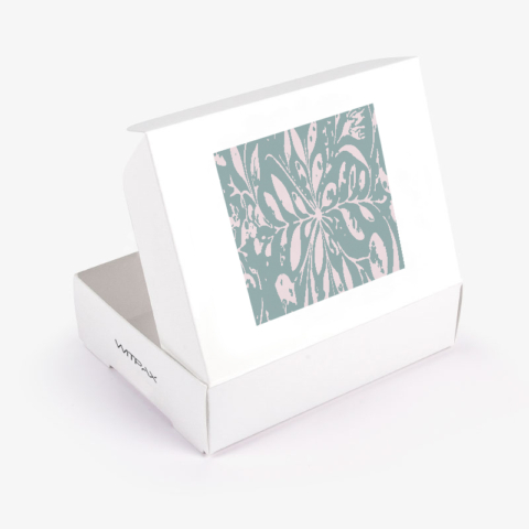 White flip top box with clear window showing green and pink floral pattern, lid open at angle