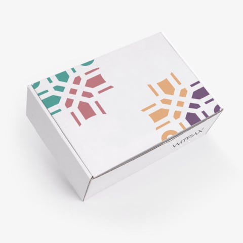 Custom white mailer box with colorful geometric die-cut pattern on closed lid