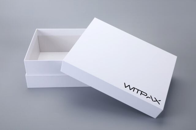 White rigid box with the lid partially open on a grey background.