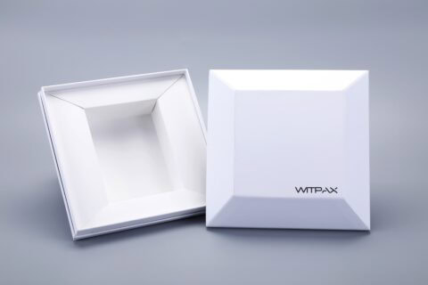 White shaped rigid boxes, one closed and one open, on a gray background.