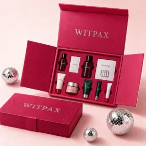 Open WITPAX raspberry skincare gift box with nine products secured in fitted insert cavities beside matching closed packaging.