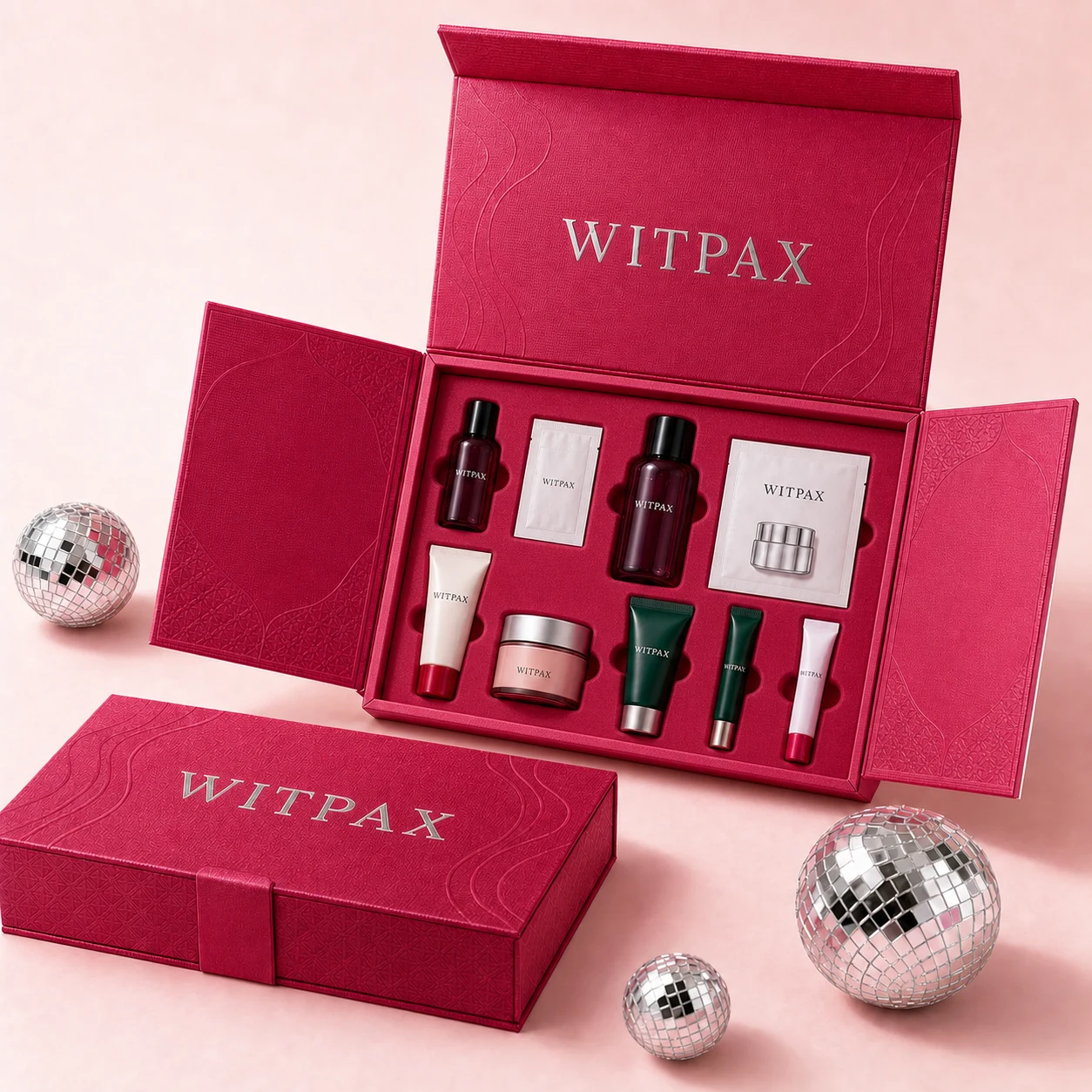 Open WITPAX raspberry skincare gift box with nine products secured in fitted insert cavities beside matching closed packaging.
