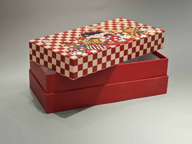 Our product is a custom-designed rectangular gift box in an appealing red color, featuring a checkered lid adorned with playful cartoon characters and food-themed illustrations. This versatile packaging solution is ideal for enhancing any occasion.